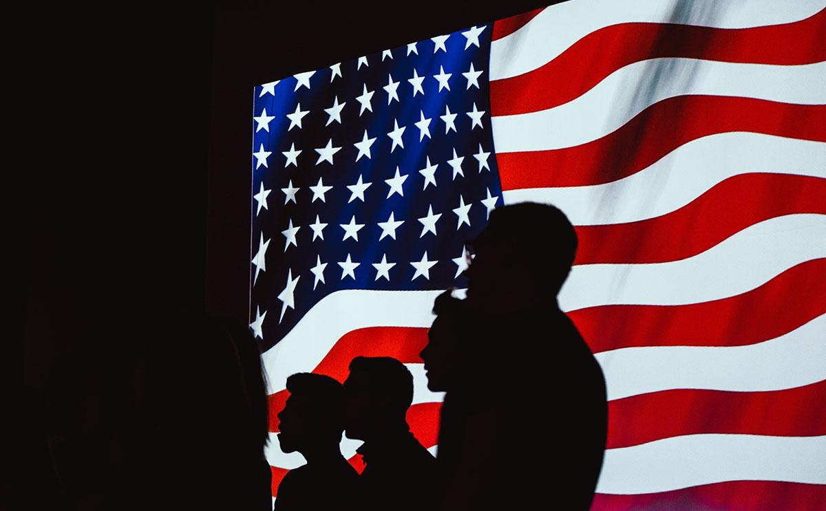 Silhouetted people on US flag